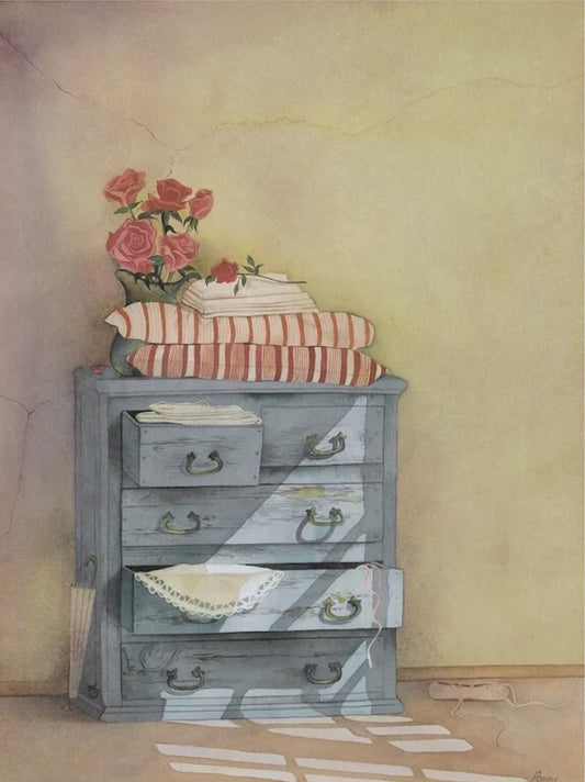 A vintage-style wooden dresser with a vase of red roses on top, and a striped pillow and folded blanket on the surface.